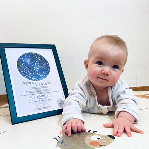 Baby mit Urkunde über Sternpatenschaft